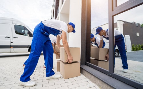 deux-employes-entreprise-demenagement-dechargeant-cartons-meubles-minibus